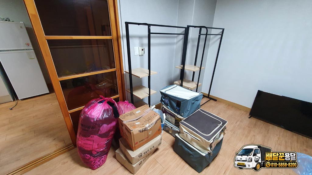 작은 원룸에 봉투2개, 리빙박스5개, 이불및 옷이 들어있는 봉투2개, 그리고 옷걸이와 티비가 정리된 모습
