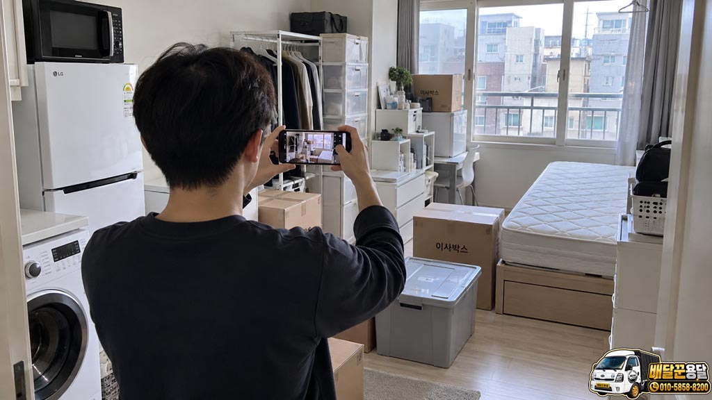 원룸 전체와 큰 가전·가구, 이사박스를 스마트폰으로 촬영하는 모습